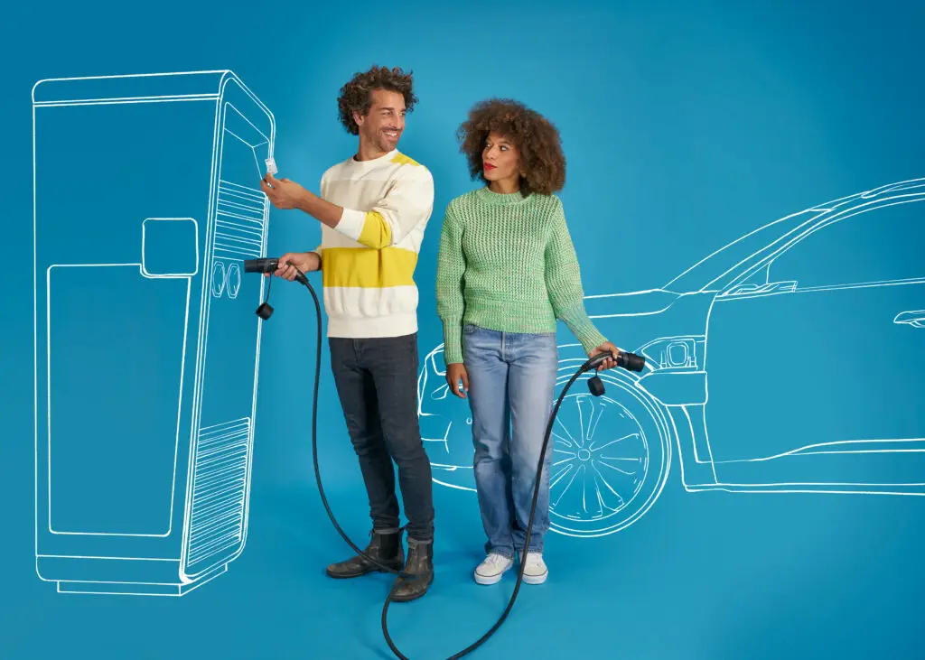 Paar mit Elektroautoladegerät vor einer skizzierten Ladestation und einem Elektroauto, symbolisiert die Zukunft der nachhaltigen Mobilität.