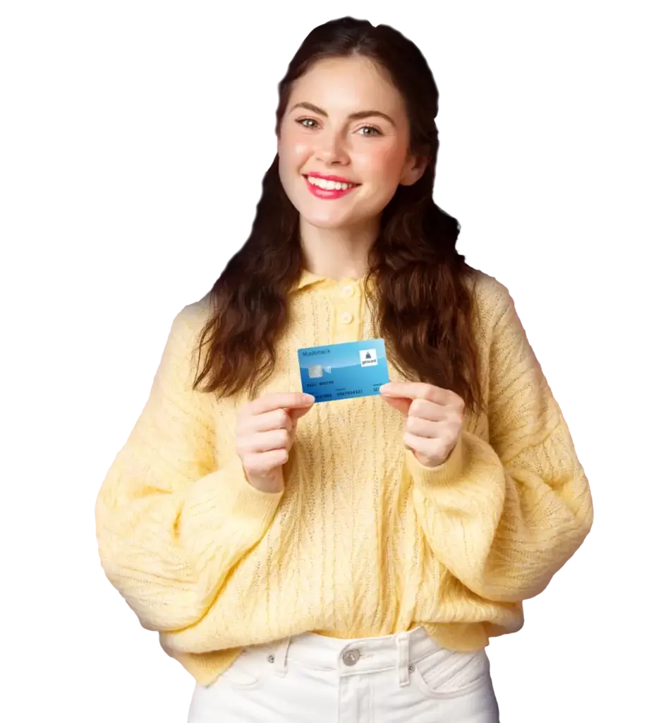 Junge Frau in einem gelben Pullover hält stolz eine blaue Kreditkarte in der Hand und lächelt freundlich in die Kamera.